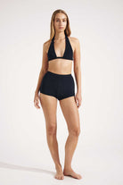 Woman wearing a black bikini set on a white background