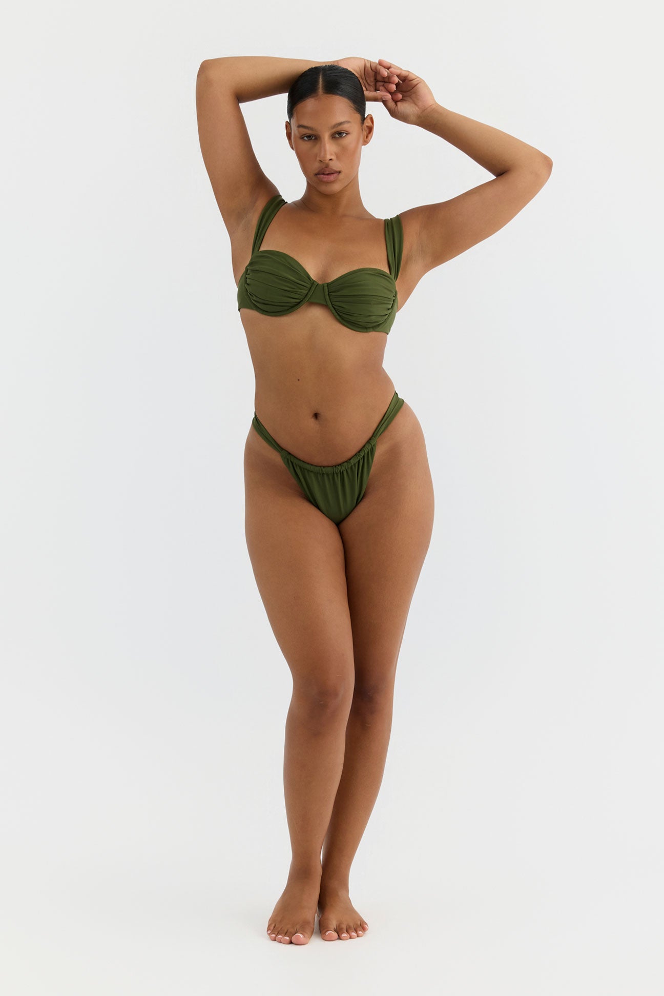 Woman wearing a green bikini against a white background