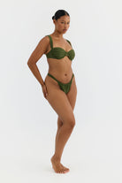 Woman wearing a green bikini on a white background