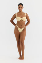Woman wearing a yellow bikini on a white background
