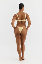 Woman wearing a yellow bikini on a white background