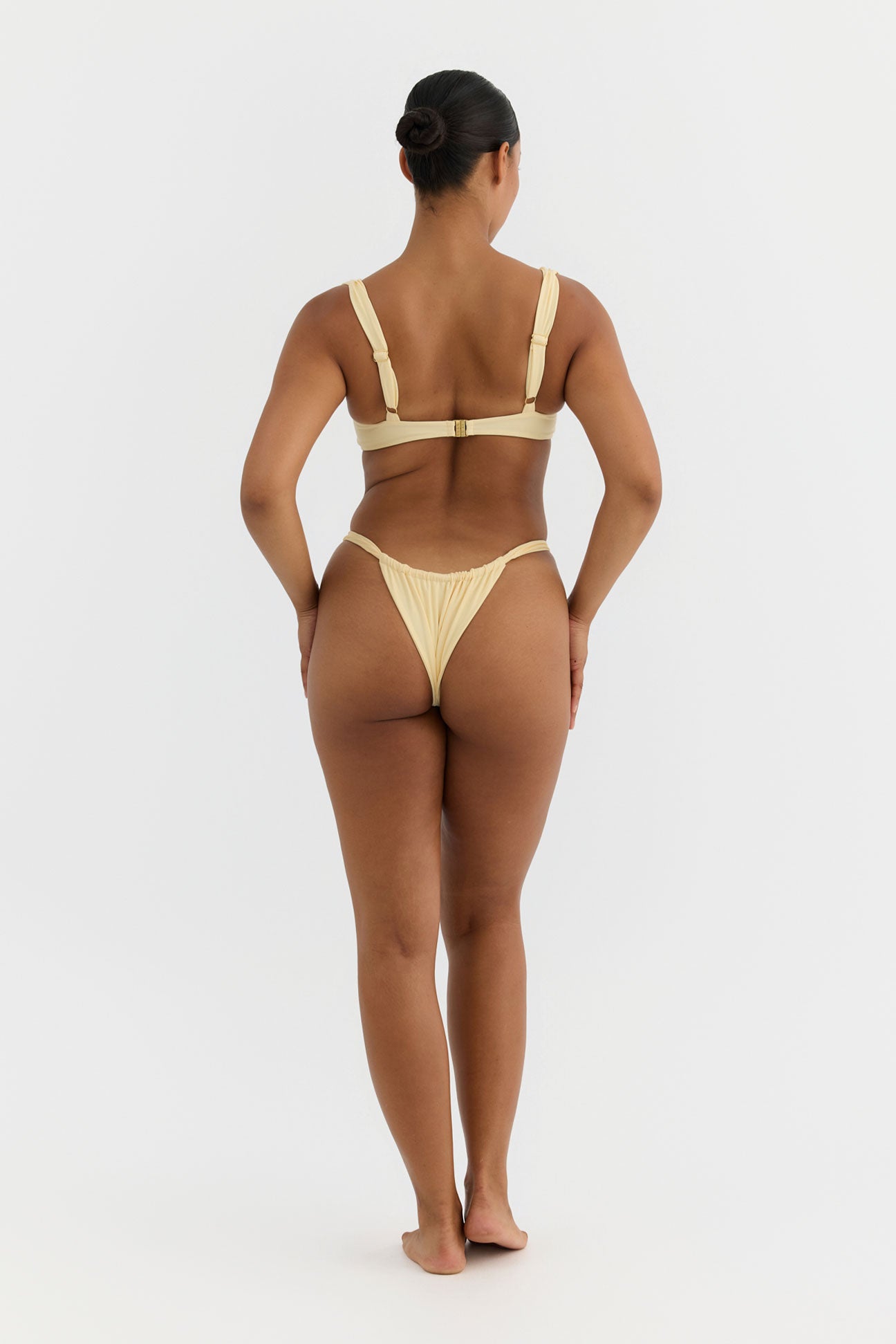 Woman wearing a yellow bikini on a white background