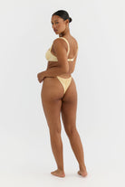 Woman wearing a yellow bikini on a white background