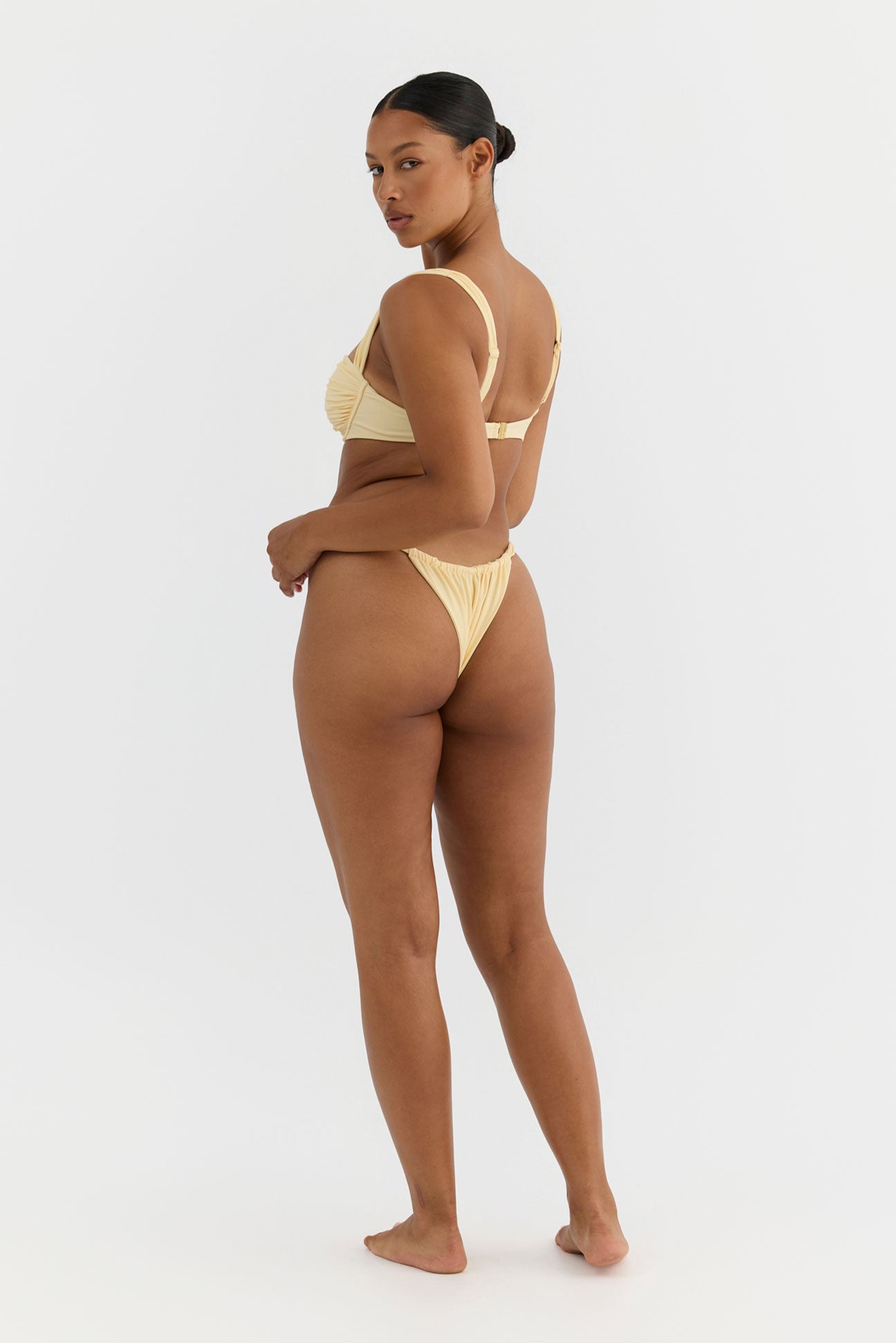 Woman wearing a yellow bikini on a white background