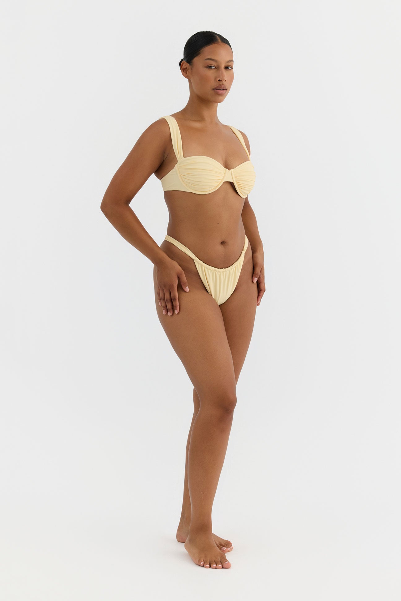 Woman wearing a yellow bikini on a white background