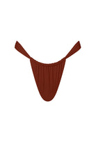 A terracotta-colored swimwear bottom with a minimalist design and adjustable straps.