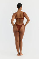 Person wearing a terracotta bikini on a white background