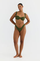 Woman wearing a green bikini on a white background