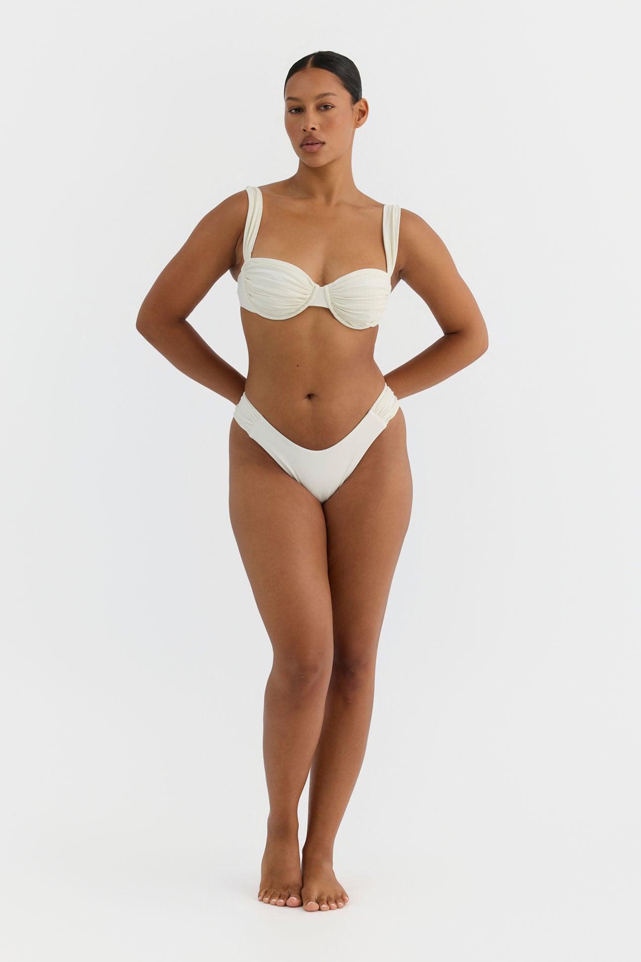 Woman wearing an ivory bikini on a white background
