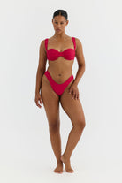 Woman wearing a pink bikini on a white background