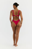 Woman wearing a pink bikini on a white background