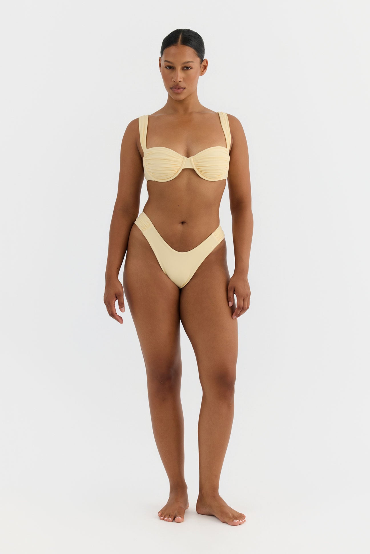 Woman wearing a yellow bikini on a white background