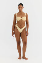 Woman wearing a yellow bikini on a white background