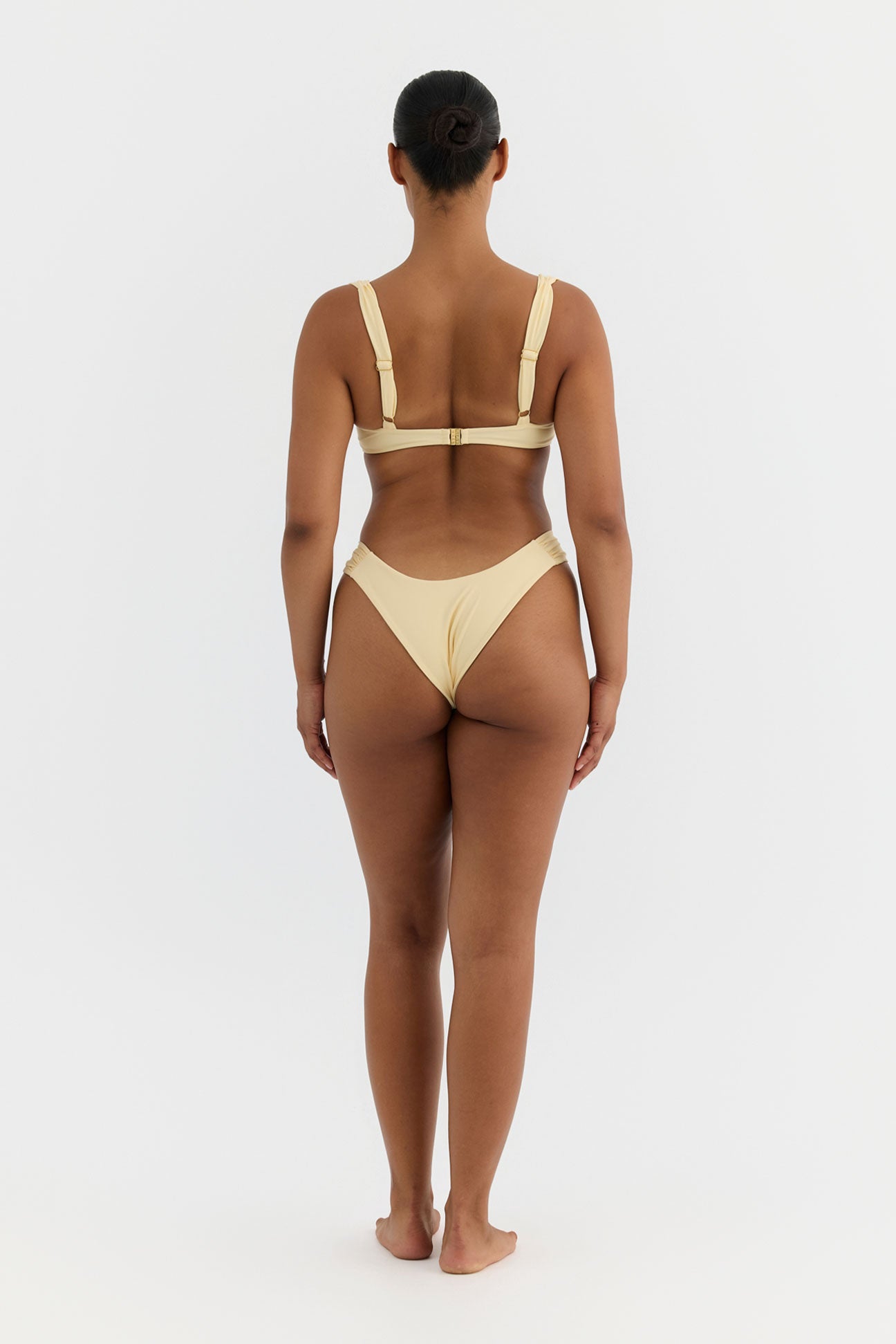 Woman wearing a yellow bikini on a white background