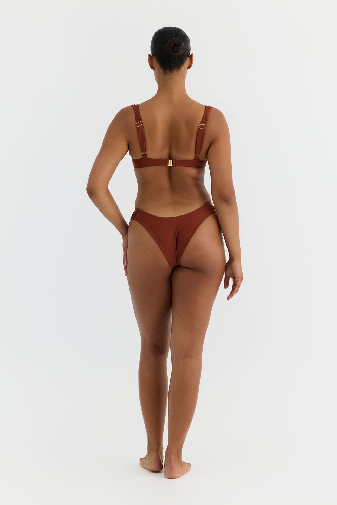 Woman wearing a terracotta swimsuit on a white background