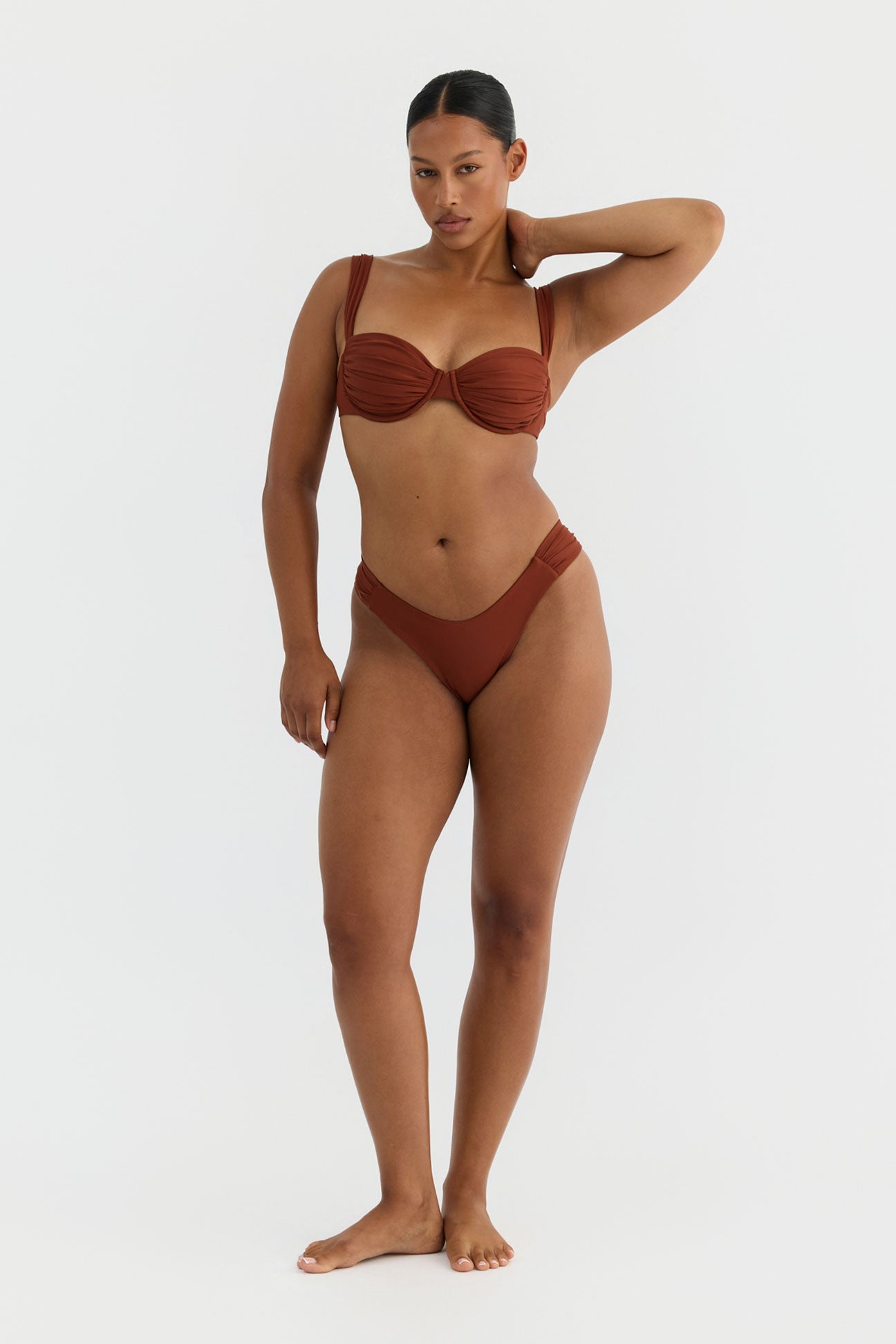 Woman wearing a terracotta bikini on a white background