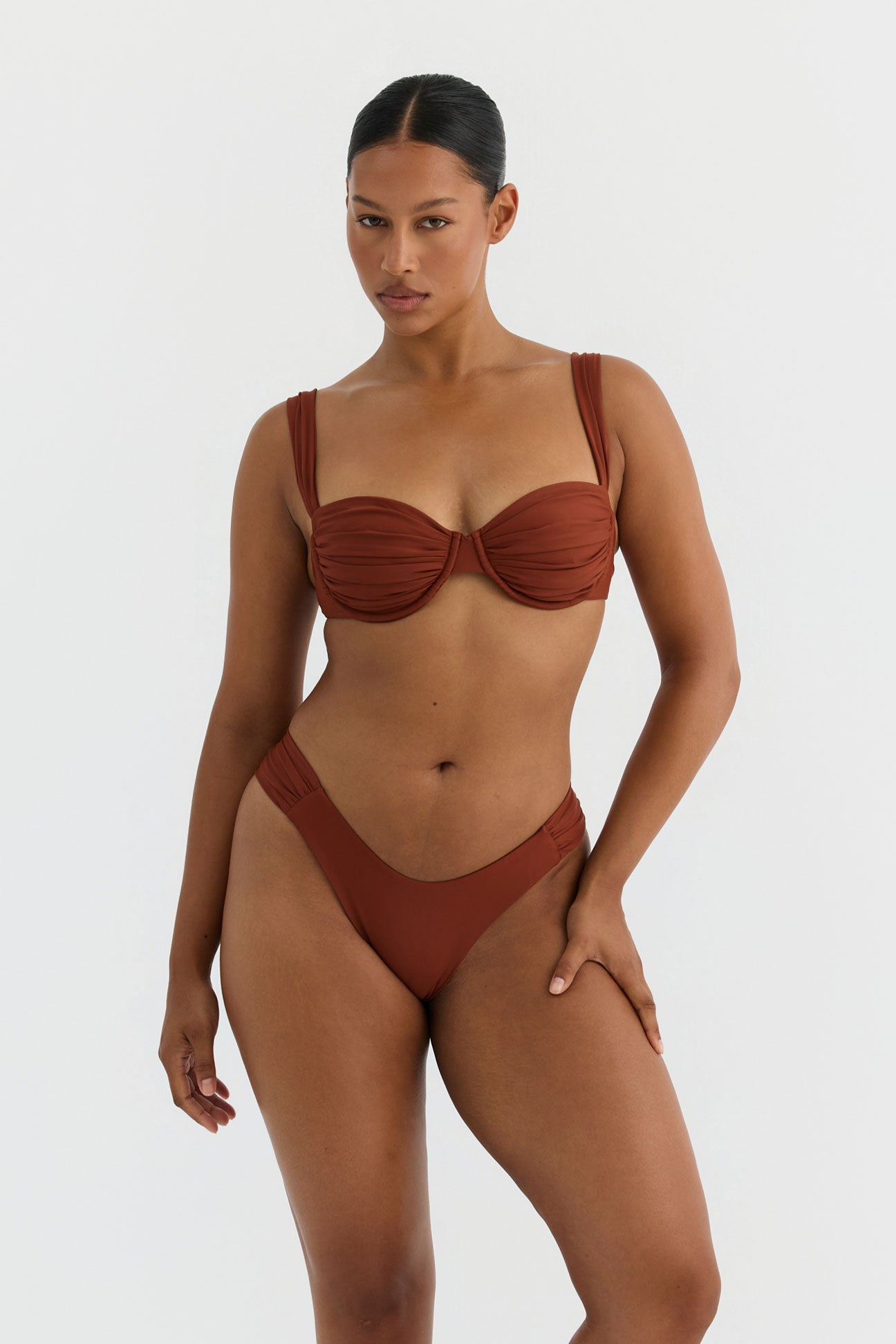 Woman wearing a terracotta bikini set on a white background
