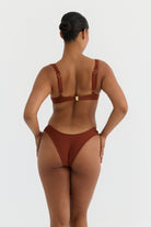 Person wearing a terracotta swimsuit on a white background
