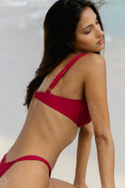 Woman in a magenta bikini on a beach