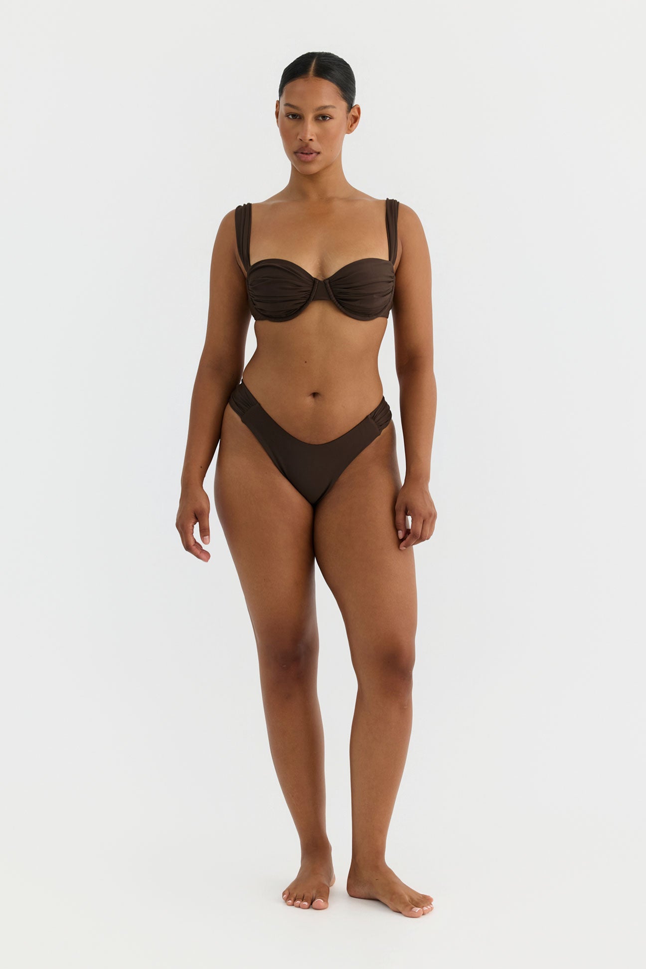 Woman wearing a brown bikini set on a white background