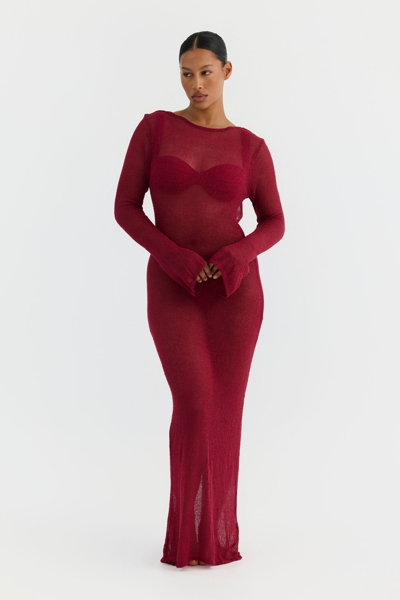 Woman wearing a magenta dress with sheer panels on a white background