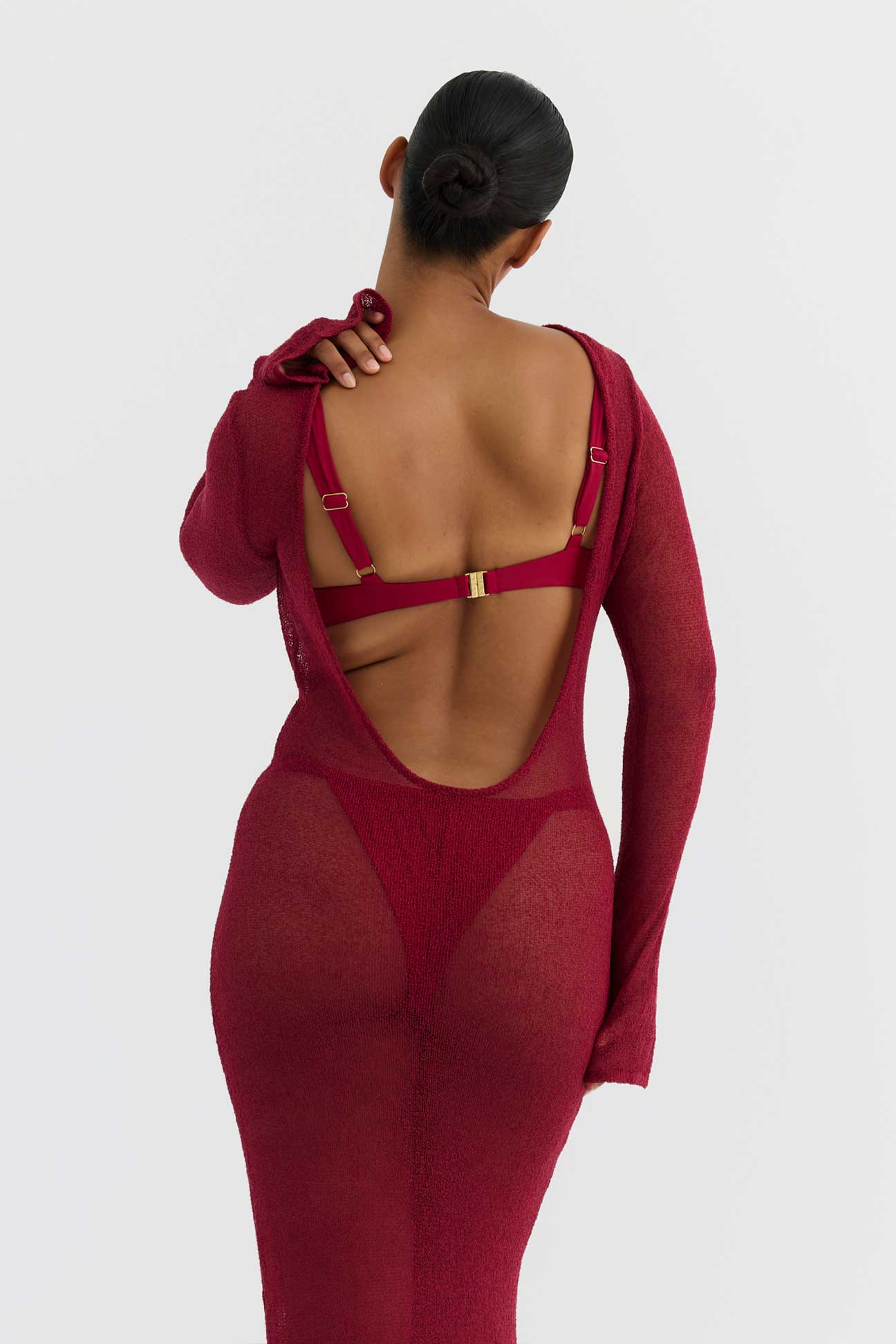 Person wearing a magenta outfit with mesh panels on a white background