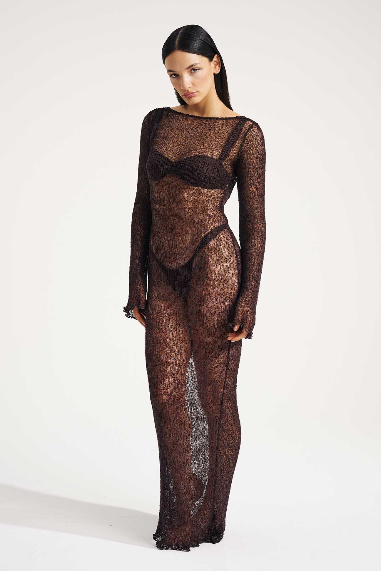 Model wearing a brown sheer dress on a white background