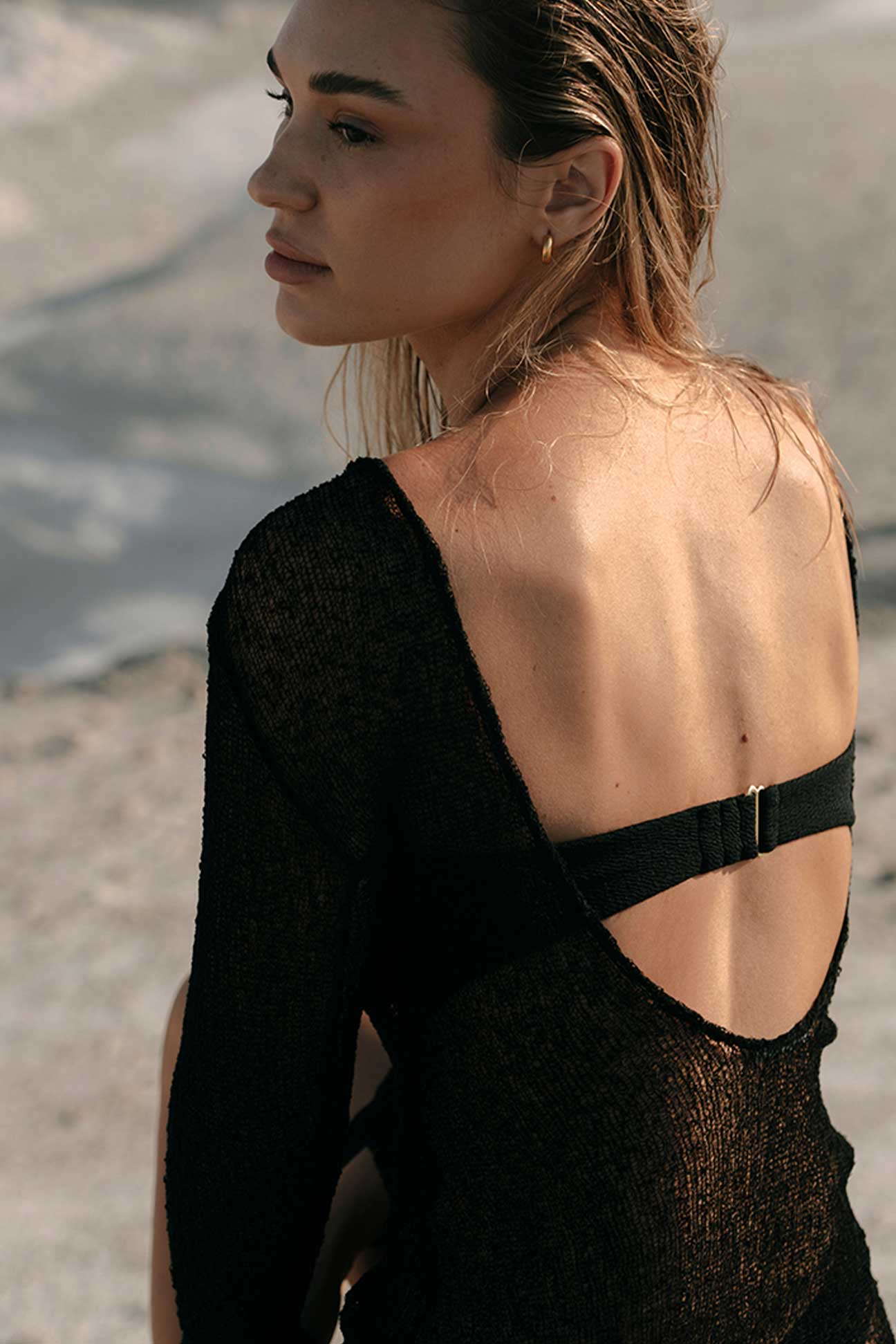 Woman wearing a black open-back dress with a blurred background