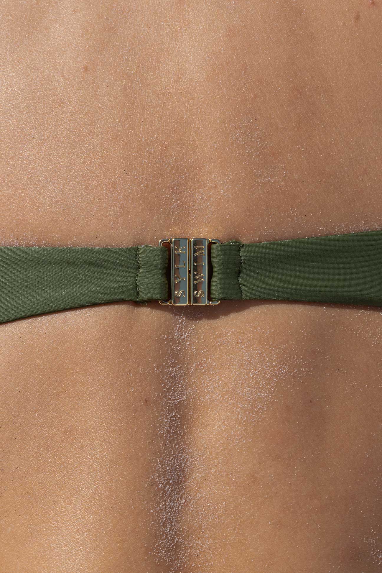 Close-up of a green bikini strap on a person's shoulder