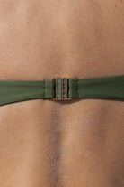 Close-up of a green bikini strap on a person's shoulder