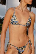 Woman wearing a floral bikini set with a blurred background