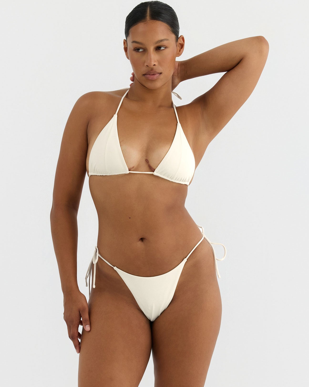 Woman wearing a white bikini against a plain background