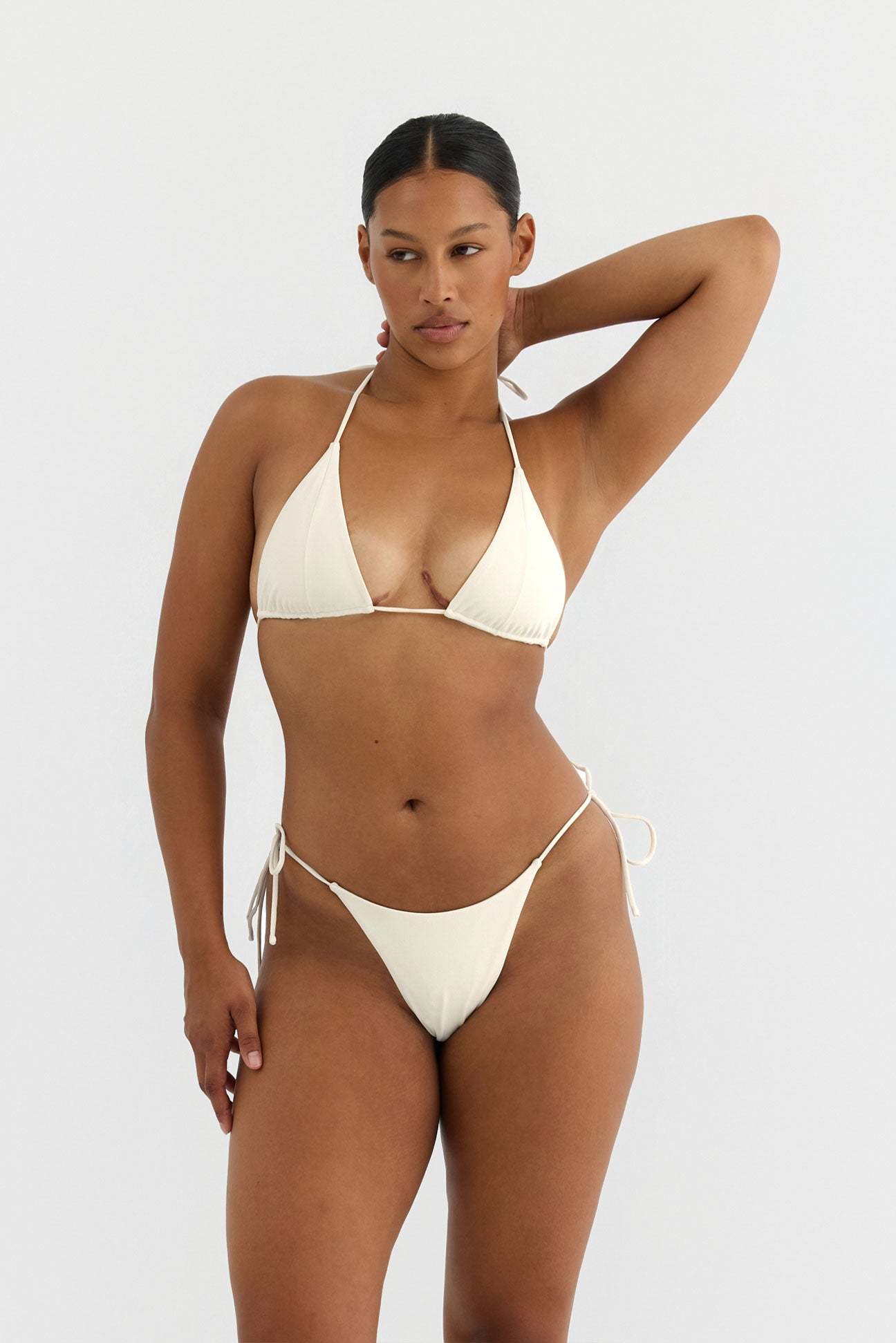Woman wearing a white bikini against a plain background
