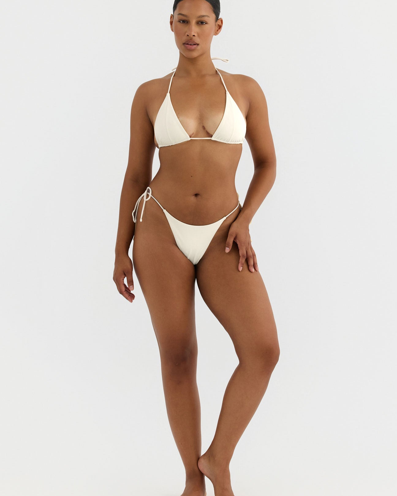 Woman wearing a white bikini on a white background
