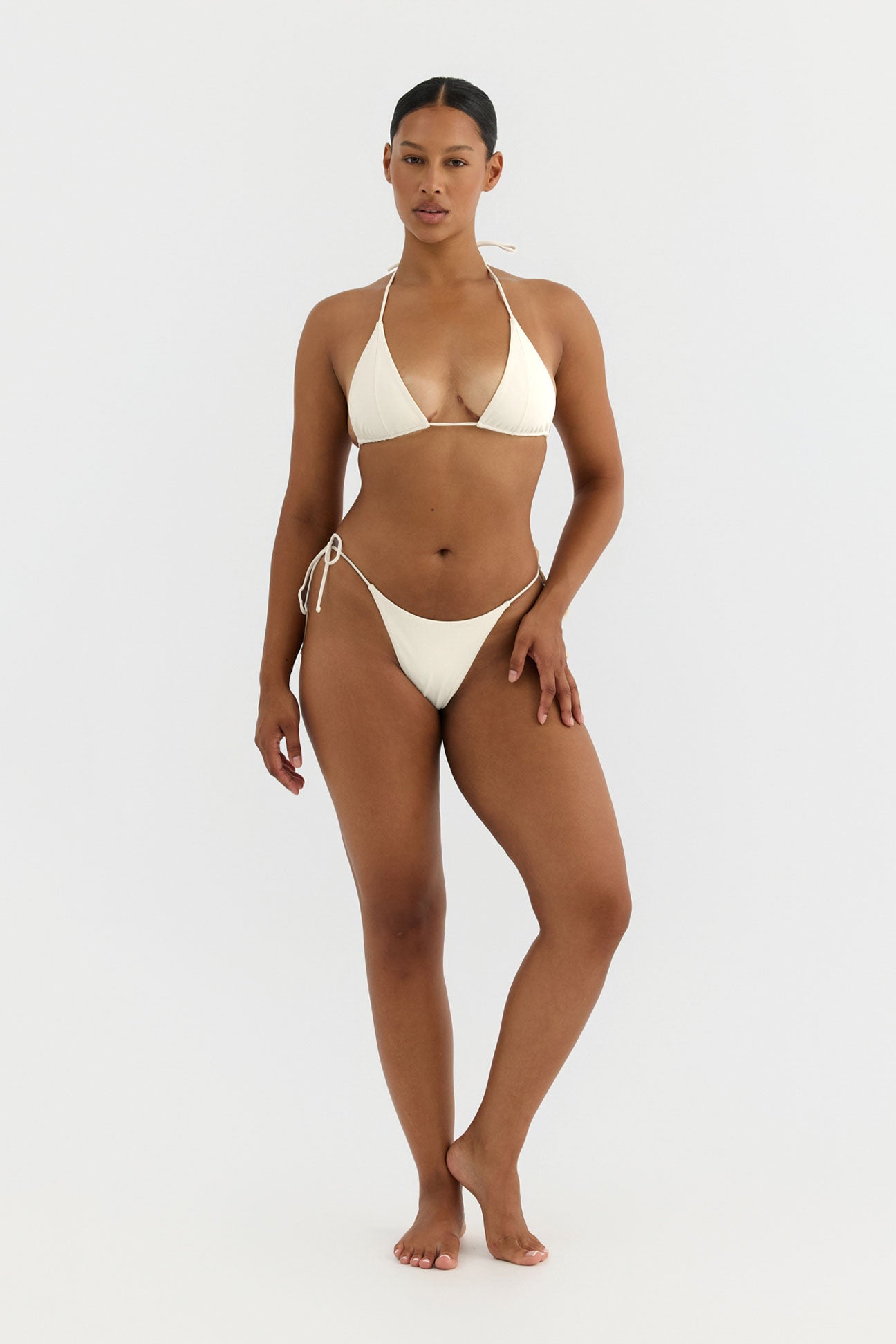 Woman wearing a white bikini on a white background