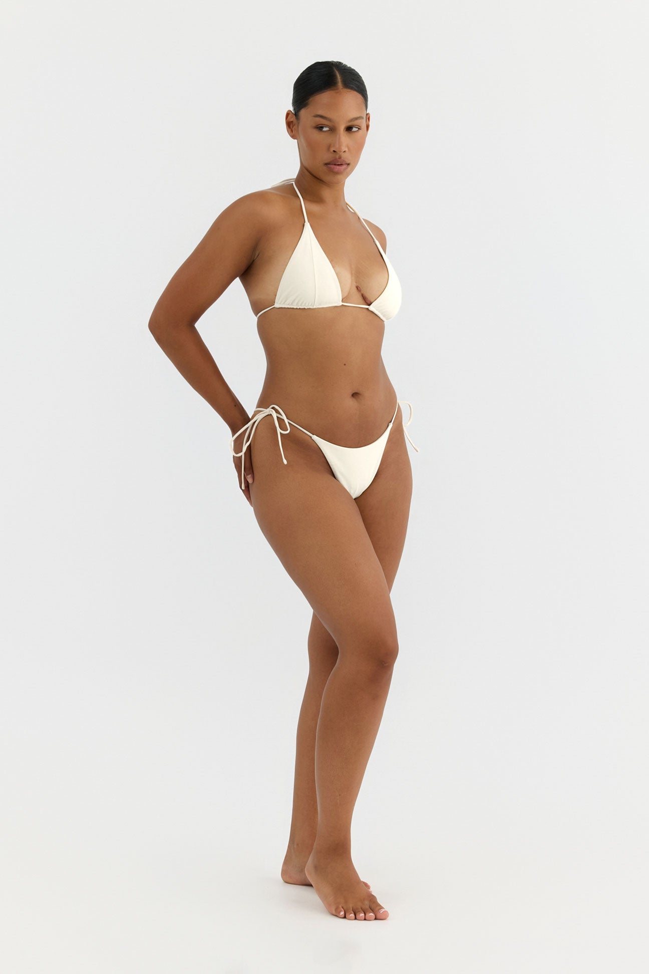 Woman wearing a beige bikini on a white background