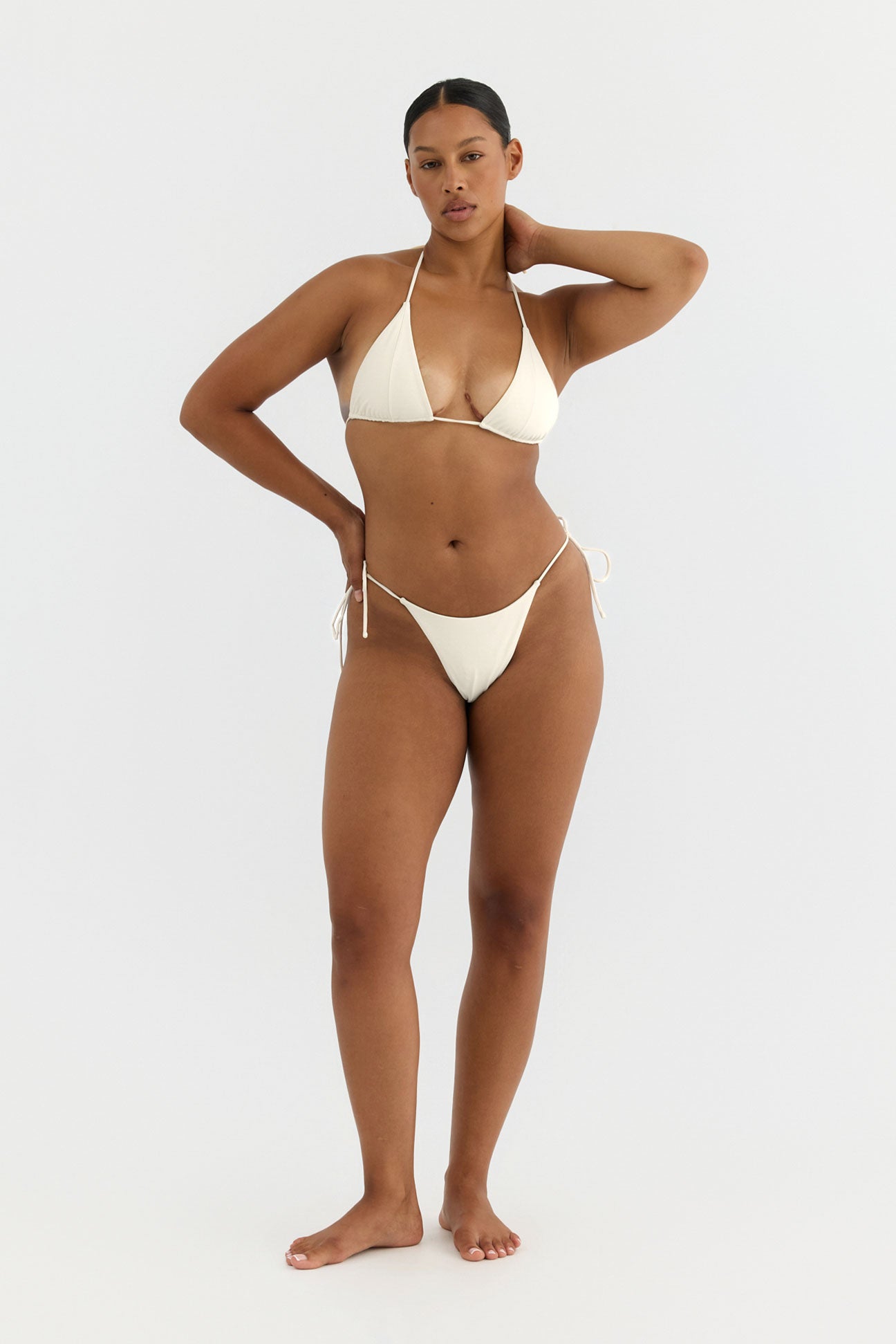Woman wearing a beige bikini on a white background
