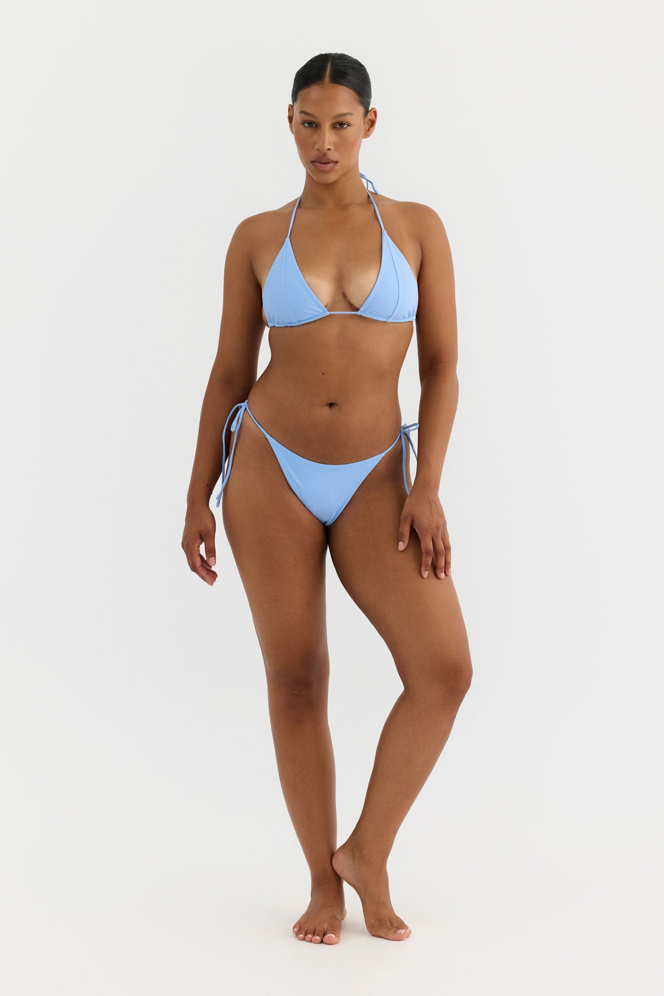 Woman wearing a light blue bikini set on a white background