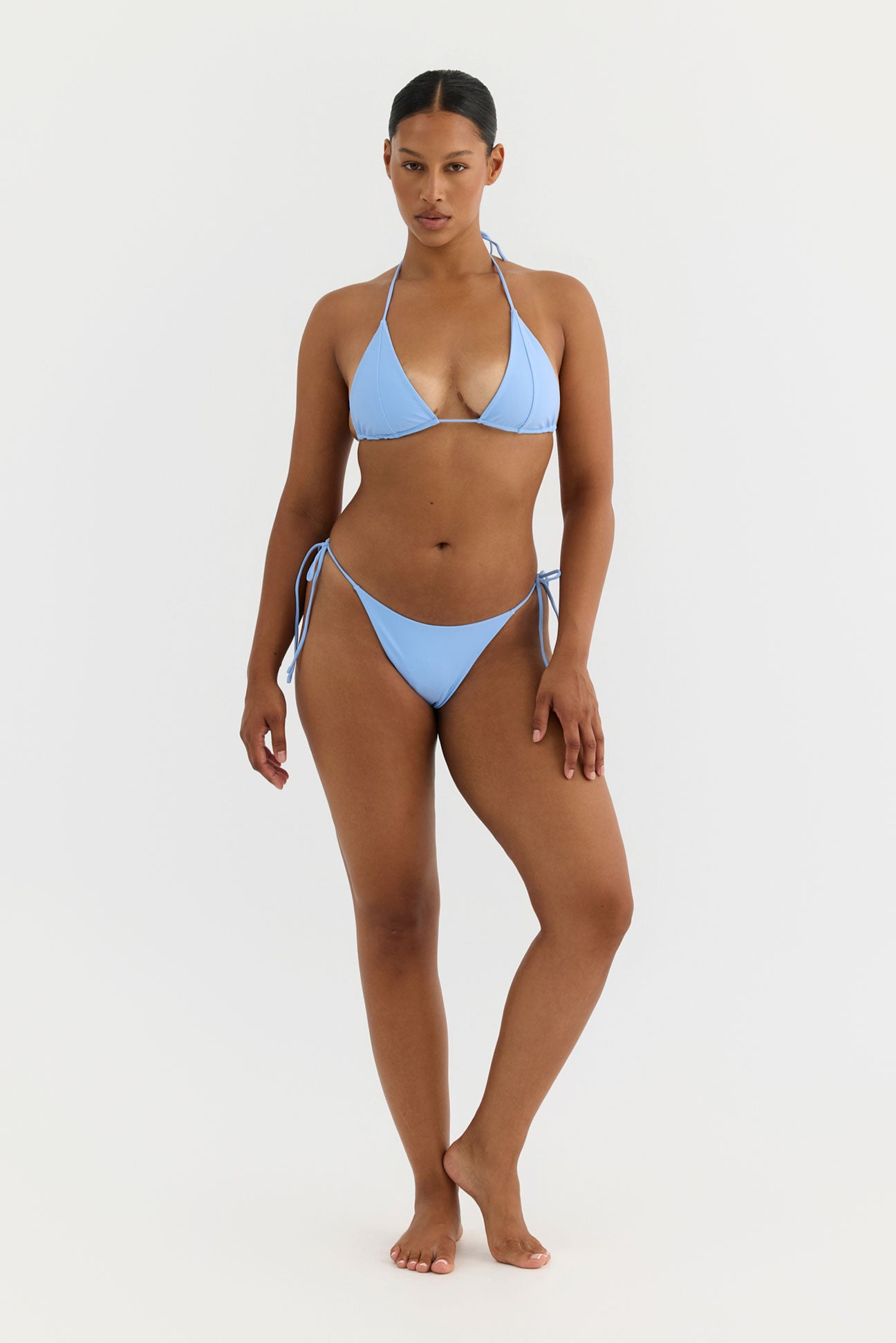 Woman wearing a light blue bikini on a white background