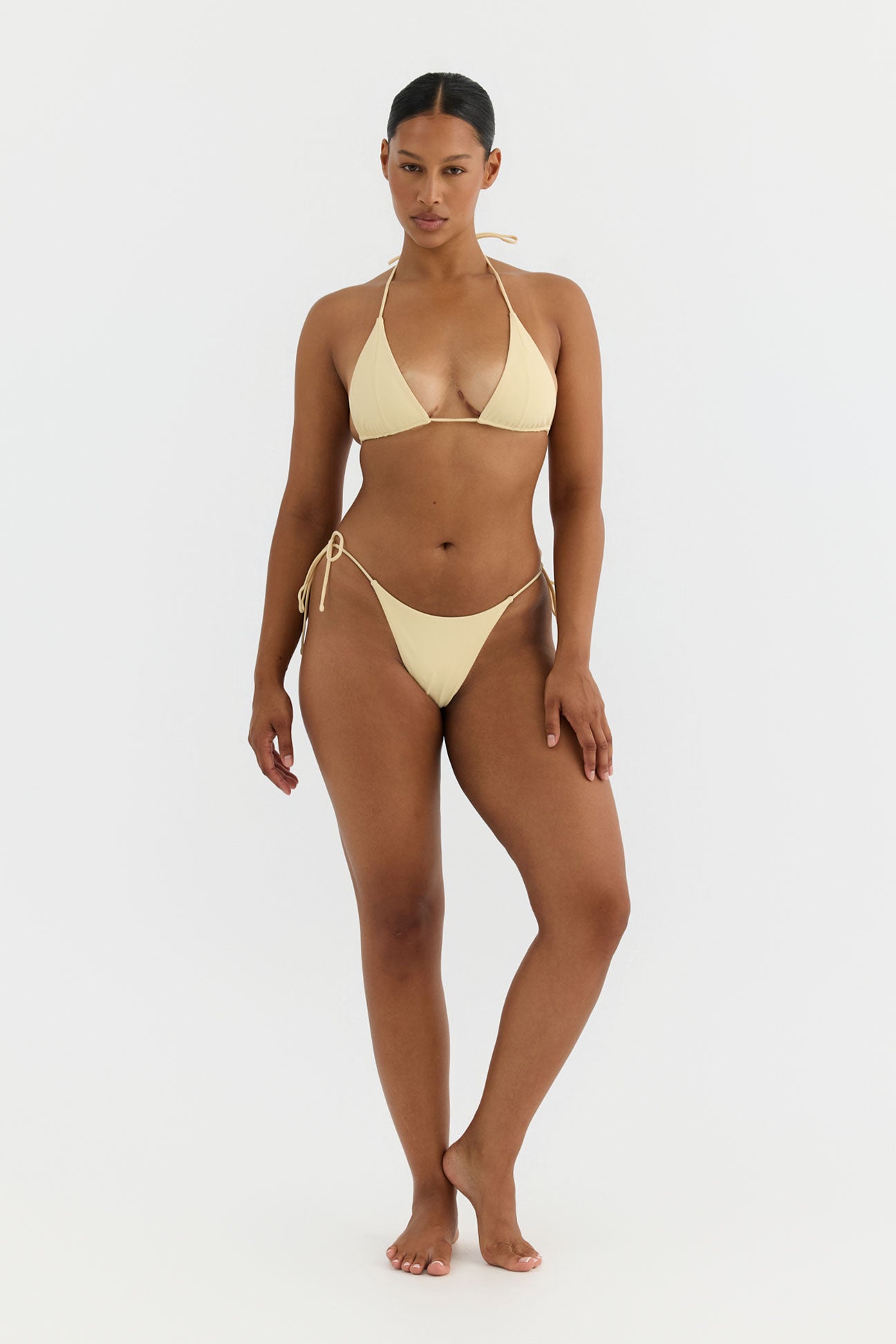 Woman wearing a yellow bikini on a white background