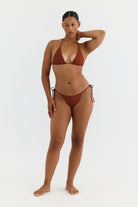 Woman wearing a terracotta bikini on a white background