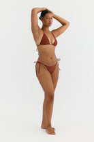 Woman wearing a terracotta bikini on a white background
