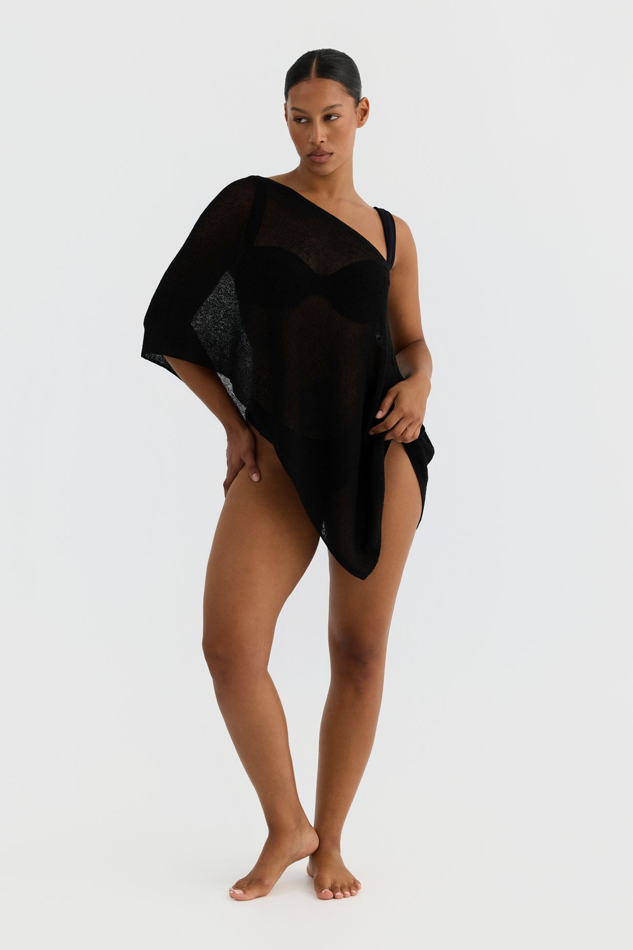 Woman wearing a black sheer cover-up on a white background