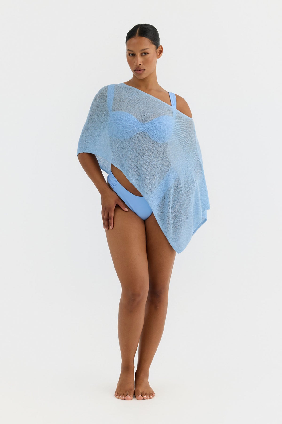 Woman wearing a light blue knit cover-up on a white background