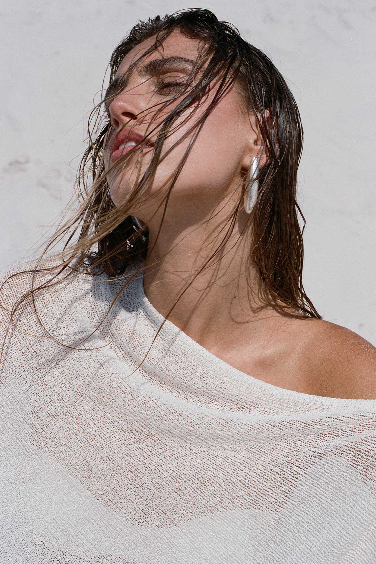 Woman with wet hair against a light background