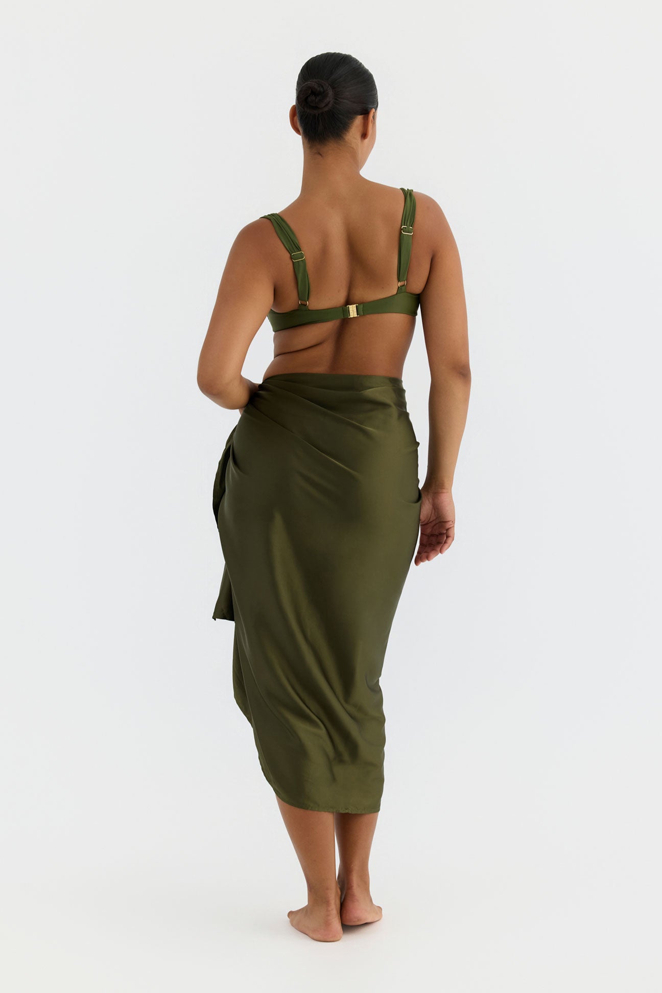 Person wearing a green cover up with a white background