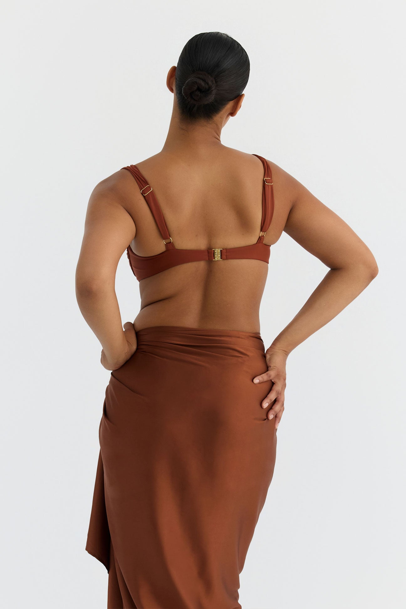 Woman wearing a bronze sarong with bikini set on a white background