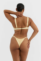 Woman wearing a yellow bikini on a white background