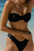 Person wearing a black bikini on a beach