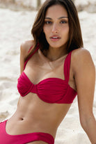 Woman wearing a magenta bikini on a beach